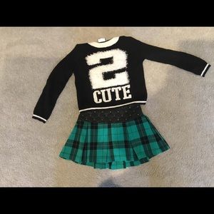 Black and white sweater and a green skirt